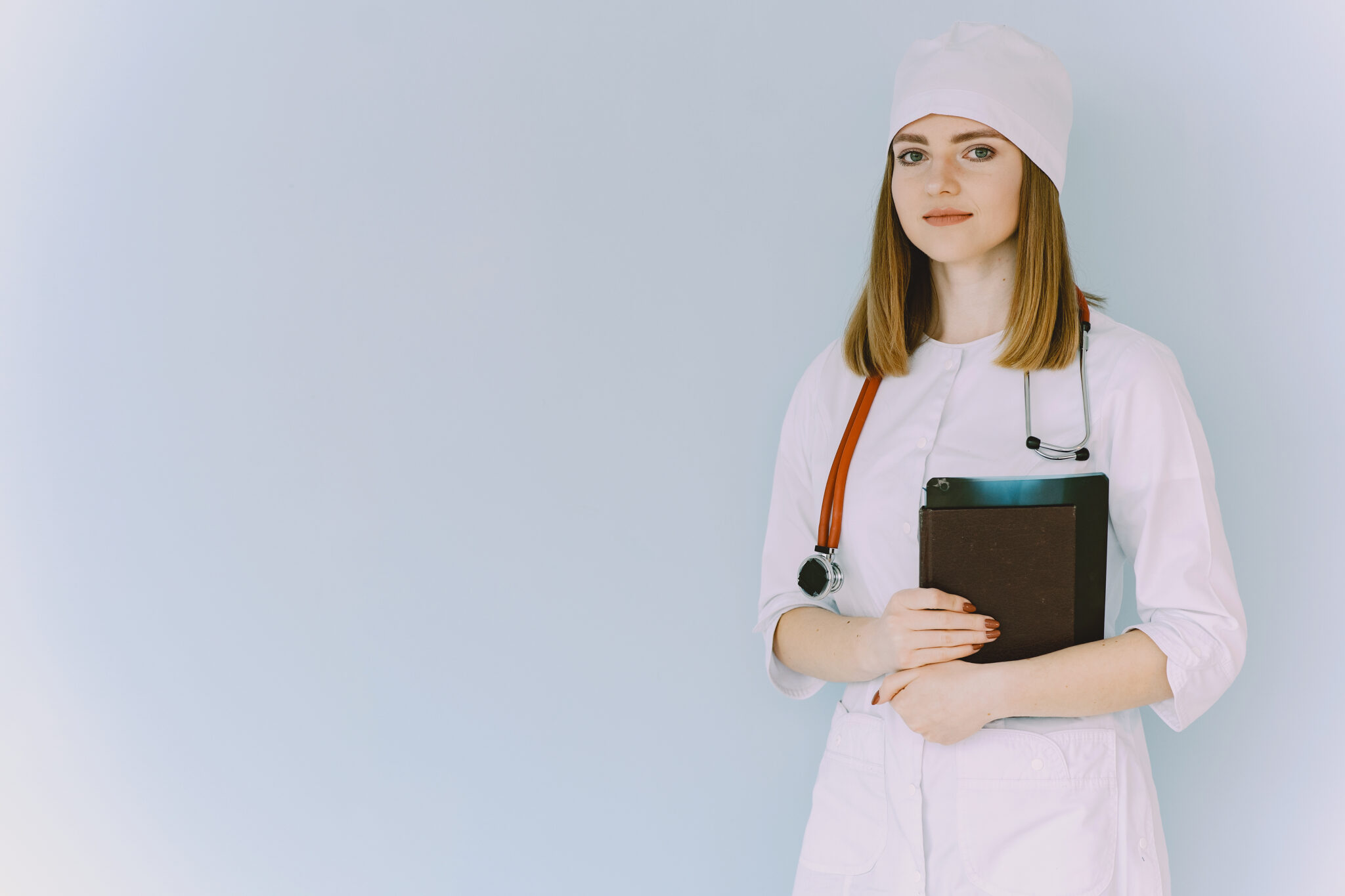 Smiling medical doctor woman with stethoscope. Isolated over white background. Image of an enthusiastic intern looking at camera